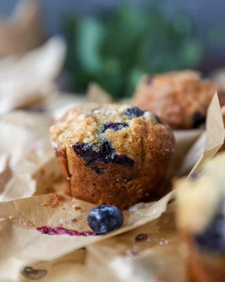 banana blueberry oat muffins baked on brown parchment paper.