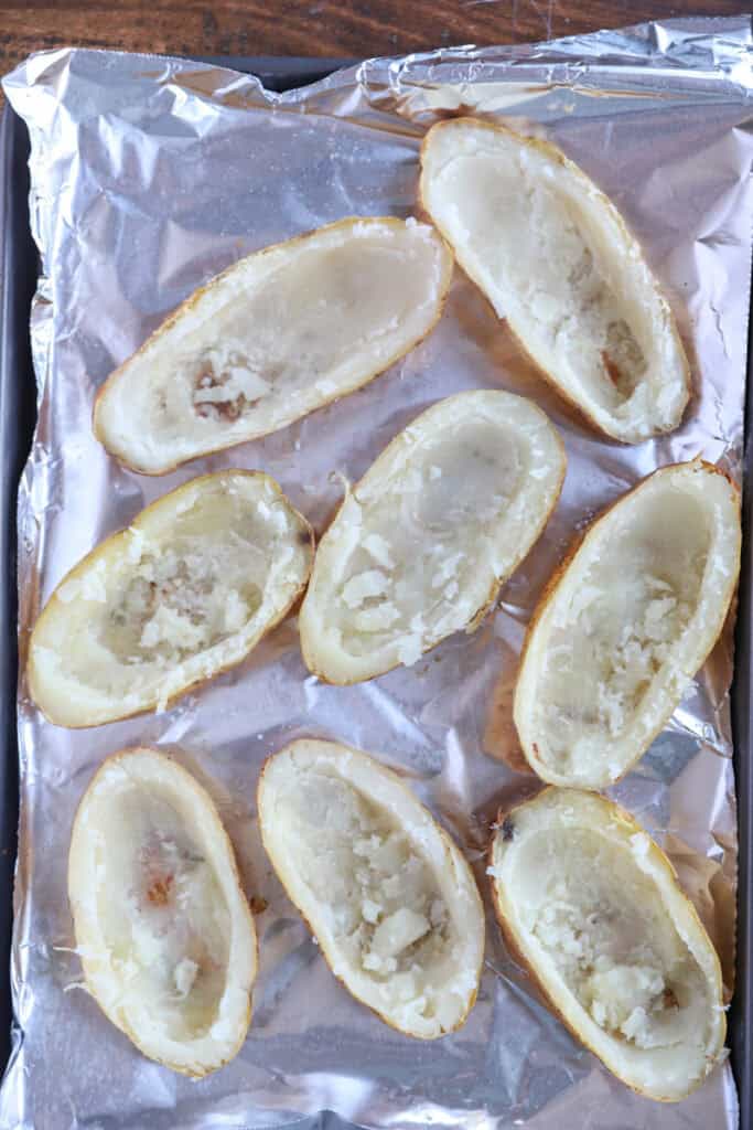 overhead photo of the empty potato skin shells on a foil lined baking sheet.