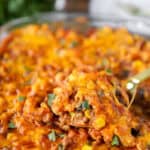 a gold serving spoon scooping from the taco pasta bake.