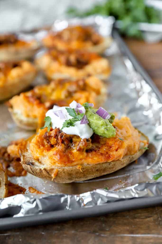A spatula lifting one taco twice baked potato from the baking sheet.