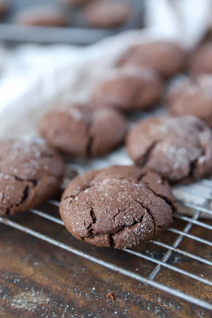 the chocolate espresso snickerdoodles on a cooling rack on a wood surface.