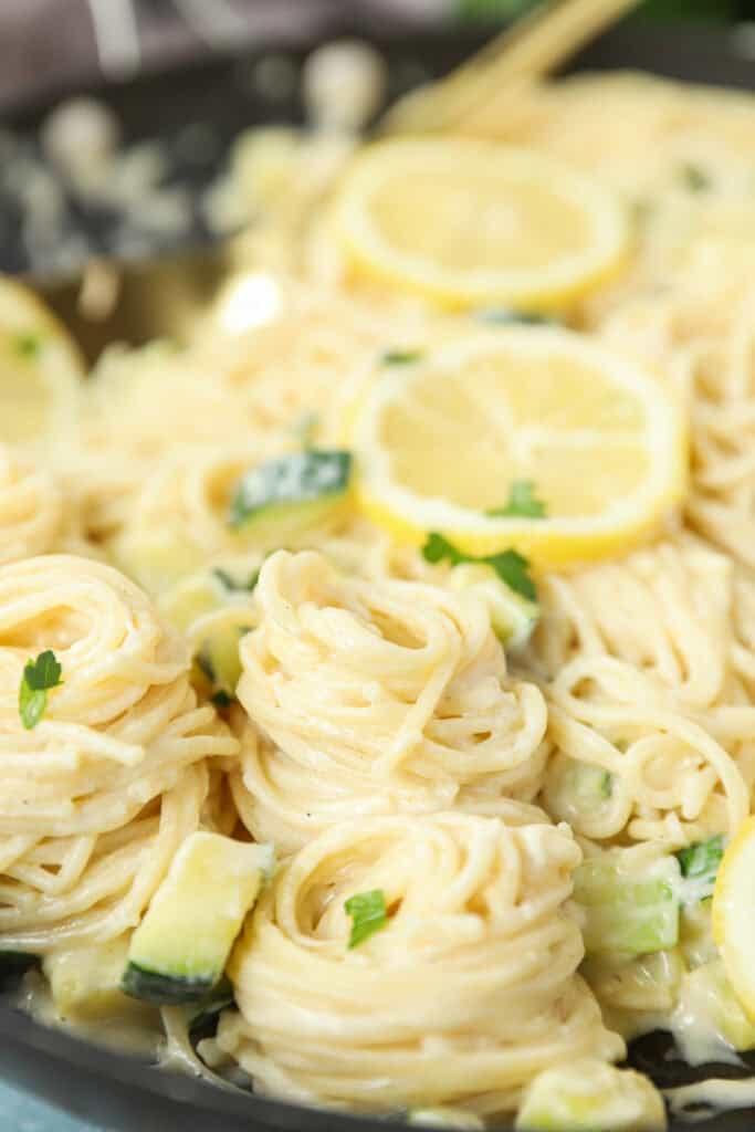 spirals of the lemon pasta linguini with lemon slices in the back.