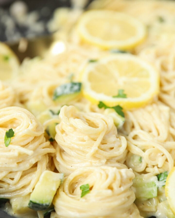spirals of the lemon pasta linguini with lemon slices in the back.