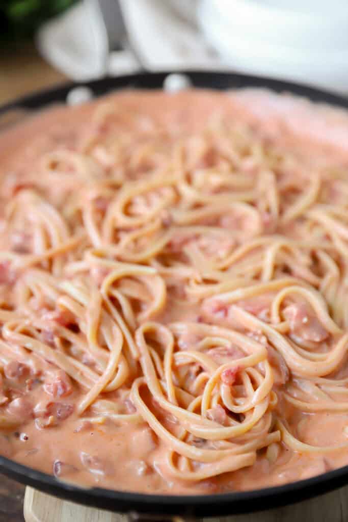  linguini noodles in bacon tomato sauce pasta in a nonstick pan.