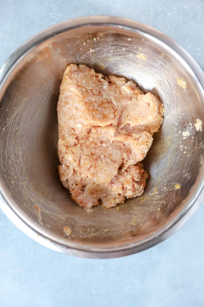 overhead photo of the seasoned ground chicken in a stainless steel bowl.