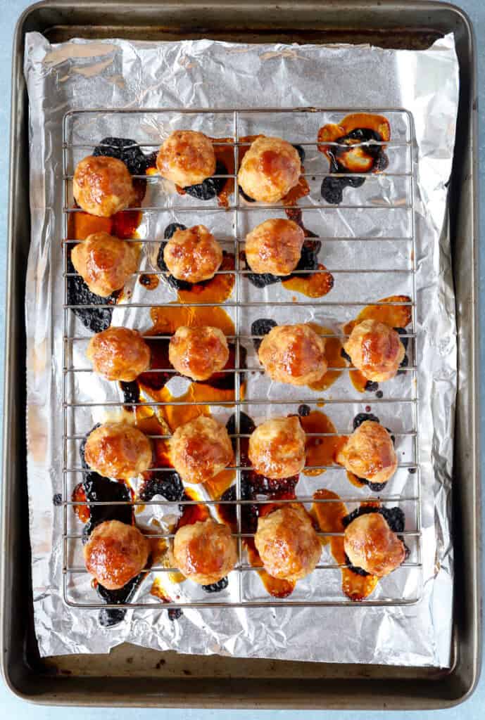 overhead photo of the baked meatballs on the foil-lined baking sheet.