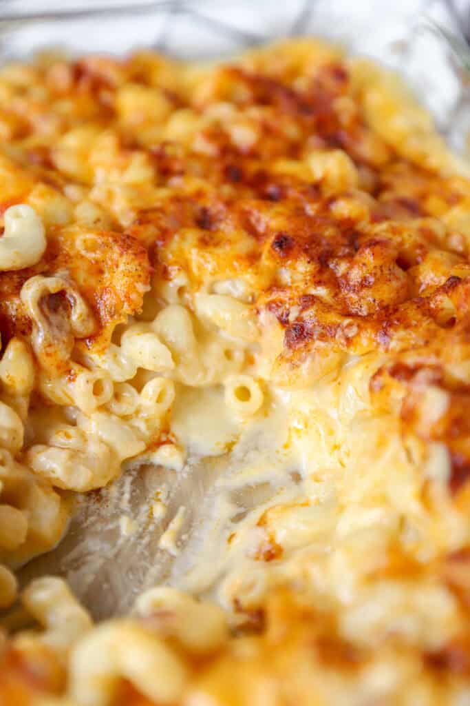 the backed mac and cheese with a scoop removed to show the cheesy interior.