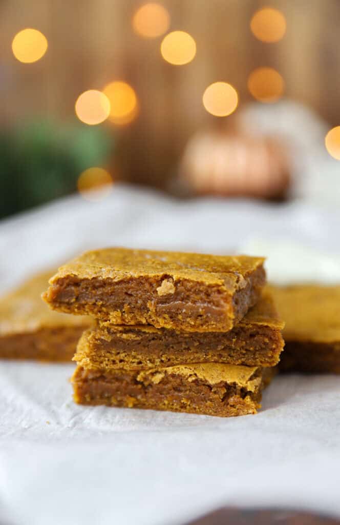 stack of 2 pumpkin cookie bars on parchment paper.